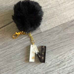 Initial N, keychain or Backpack Charm, black, white, gold with black pom-pom